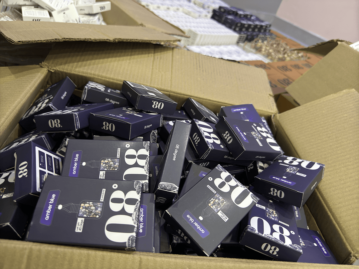 08 Degree Amber Blue packaging gathered in a carton at the packing table
