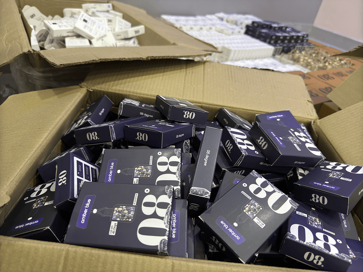 Bulk stock of 08 Degree Amber Blue boxes in an open carton