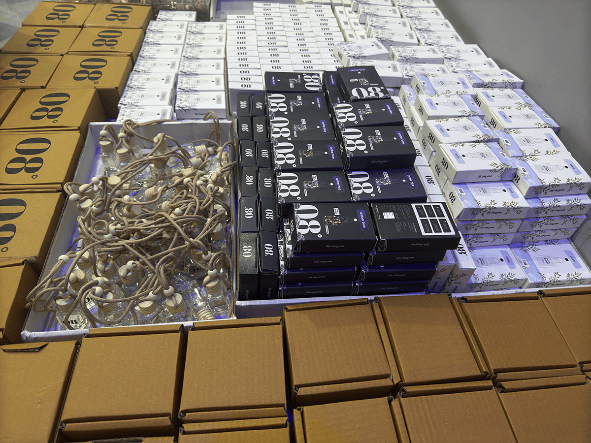 08 Degree fragrance bottles, retail boxes and brown shipping cartons arranged for packing